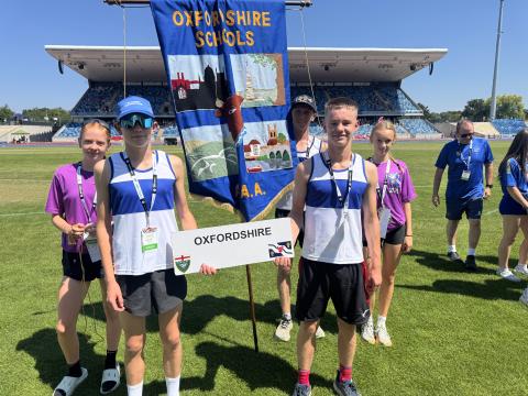 Zara Tate, Noah Spruce, Will Potts, Zac Coulson and Nia Parry-Spring with the Oxfordshire banner