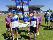 Zara Tate, Noah Spruce, Will Potts, Zac Coulson and Nia Parry-Spring with the Oxfordshire banner